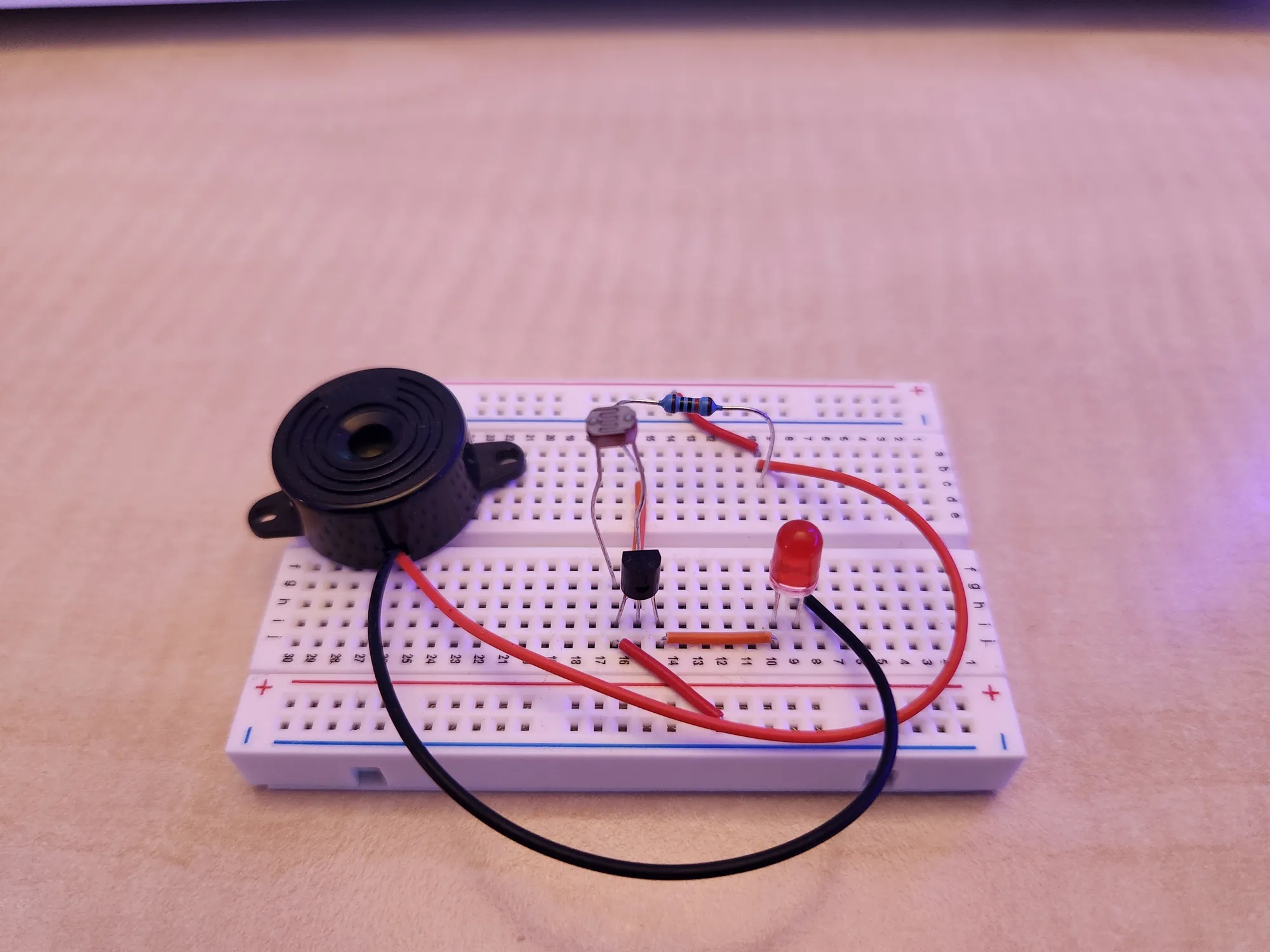 Laser alarm system built on a breadboard with buzzer and red LED